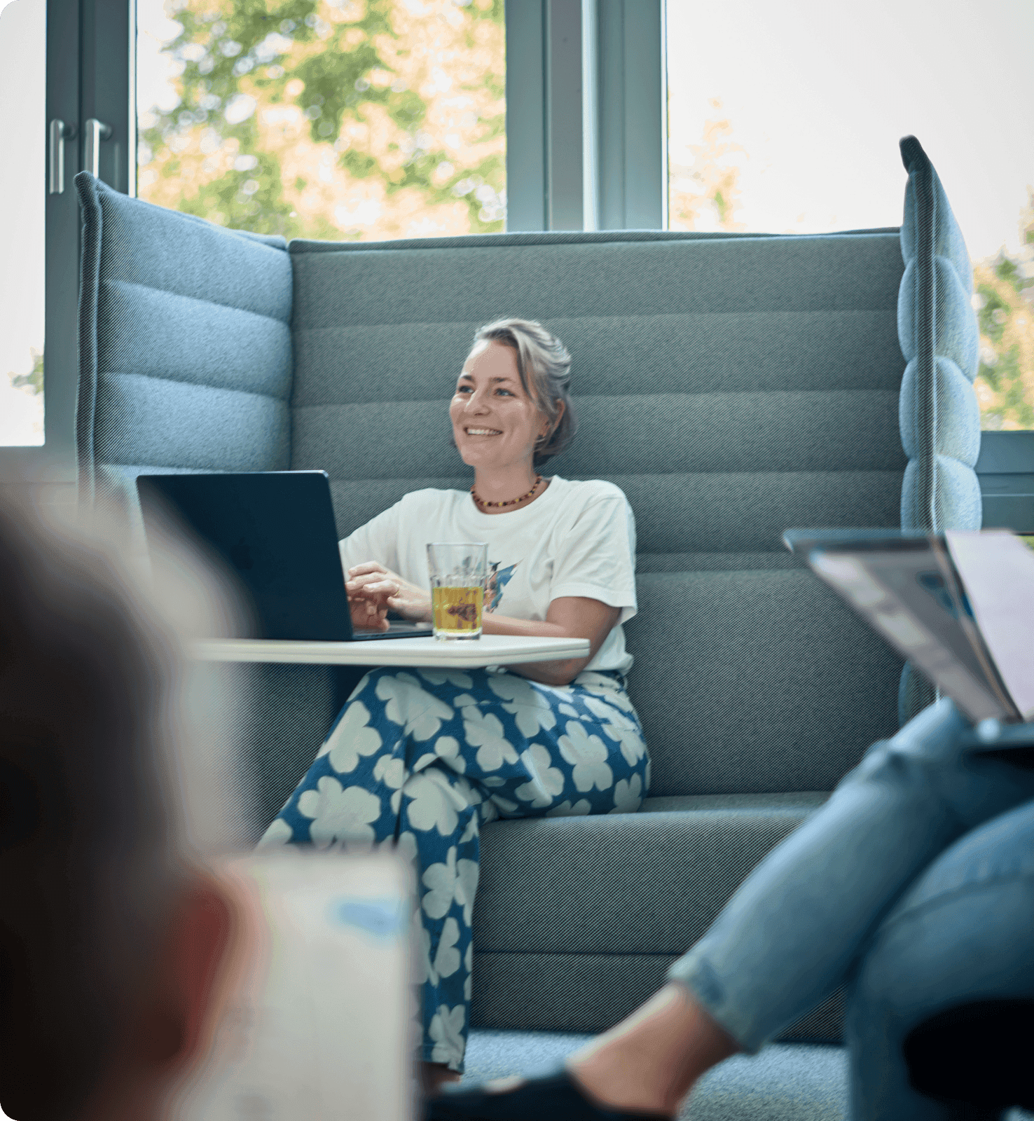 Mitarbeiterin in einer Sitzecke mit Laptop