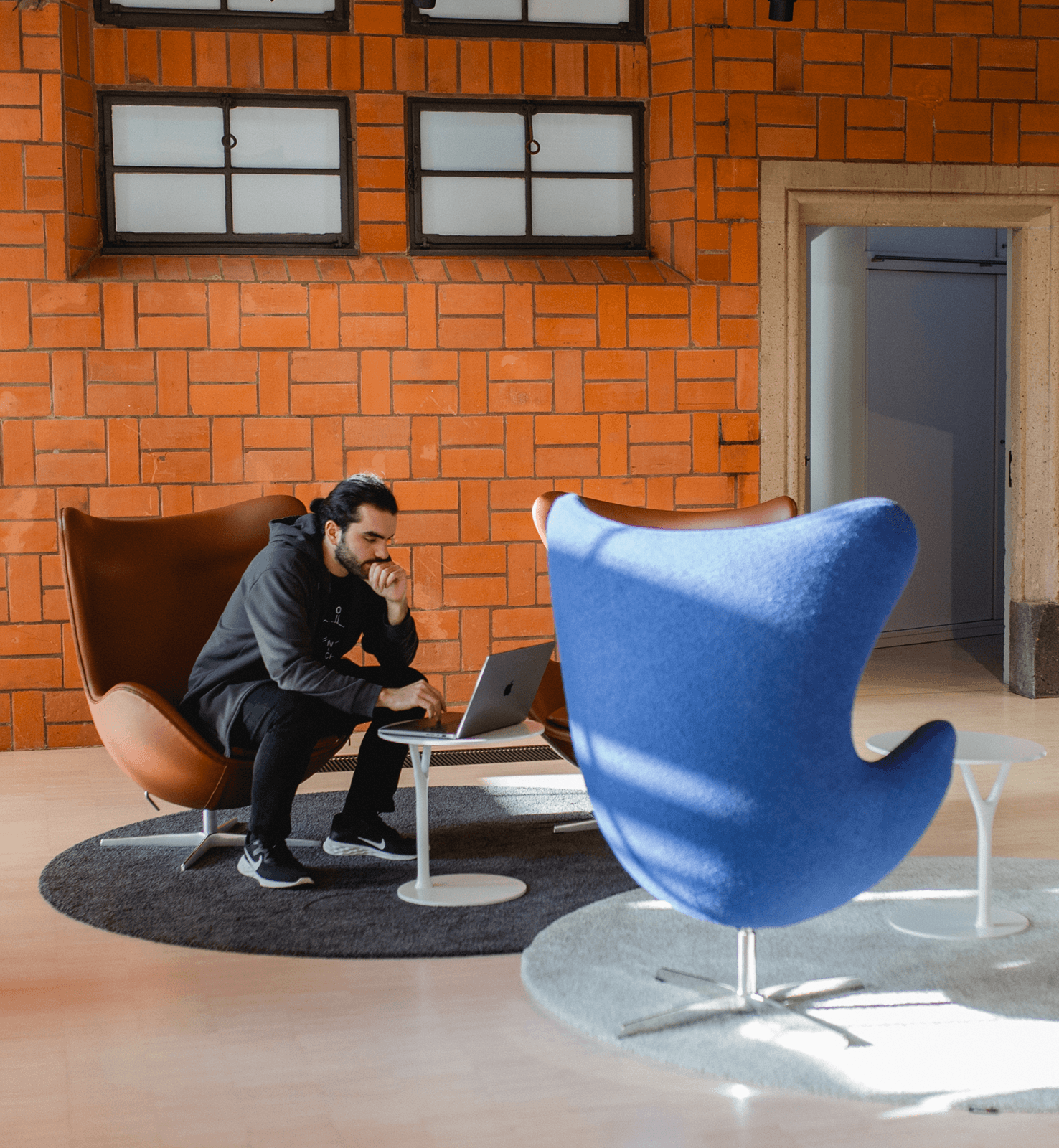 Mitarbeiter von piazza blu am Laptop im Eingangsbereich mit Sesseln